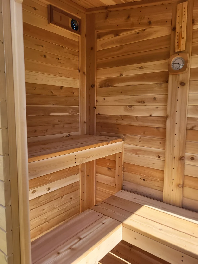 Corner of a cedar sauna interior with an L-shaped bench.